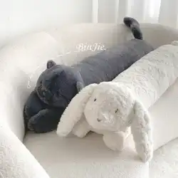 女の子の猫の人形を寝かしつけ、かわいいウサギのぬいぐるみの人形を持ってベッドで人形を分解して洗うための長い枕